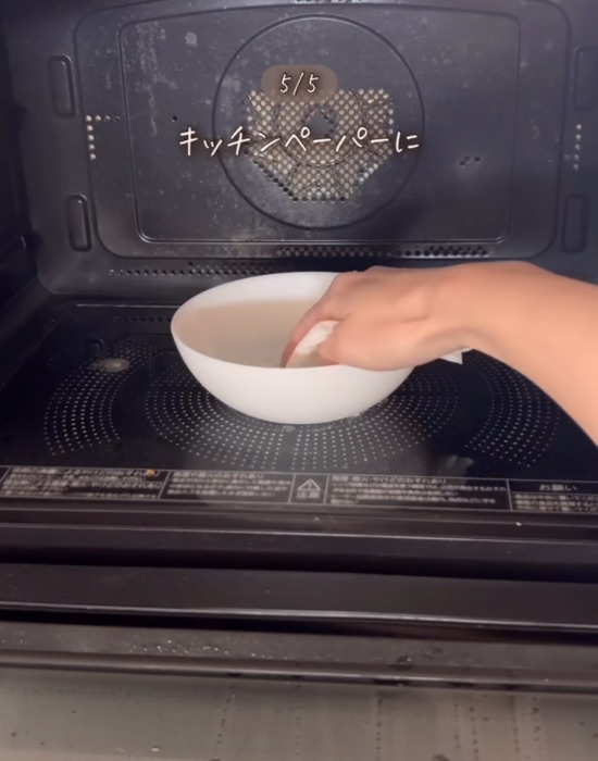 アルカリ電解水の入ったお皿にキッチンペーパーを入れる様子