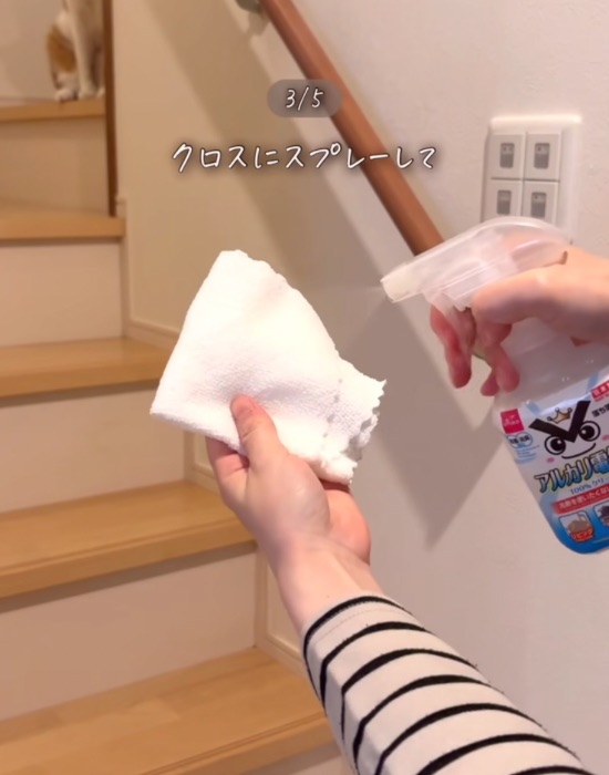 アルカリ電解水をクロスに吹きかける様子