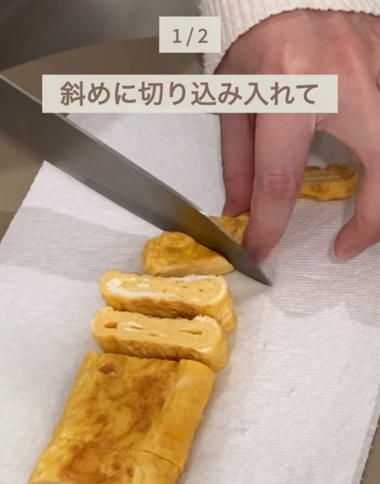 縦に切った卵焼きに斜めに切り込みを入れる様子