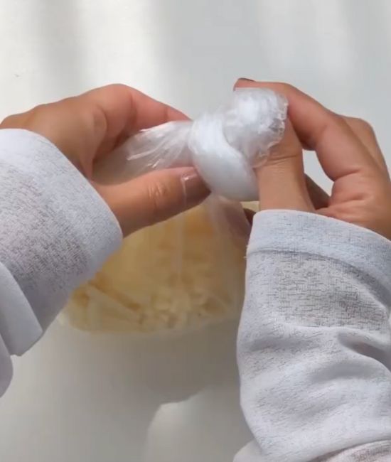 『アイラップ』にピザ用チーズを入れて袋の口を縛る様子
