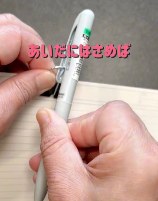 ダブルクリップのレバーにボールペンのクリップを引っかける様子
