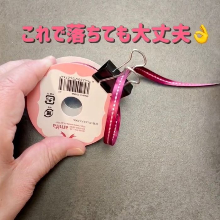 ダブルクリップのレバーにリボンの先端を通した状態でダブルクリップをリボンのパッケージに挟んだ様子