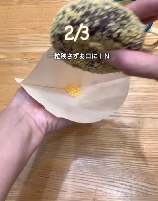 コーヒーフィルターに入ったドーナツのトッピングとドーナツを手にしている様子