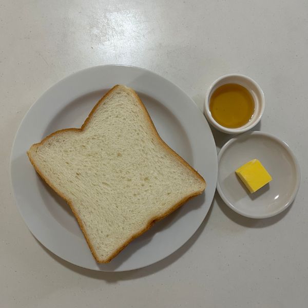 食パンとバターとハチミツを並べた写真