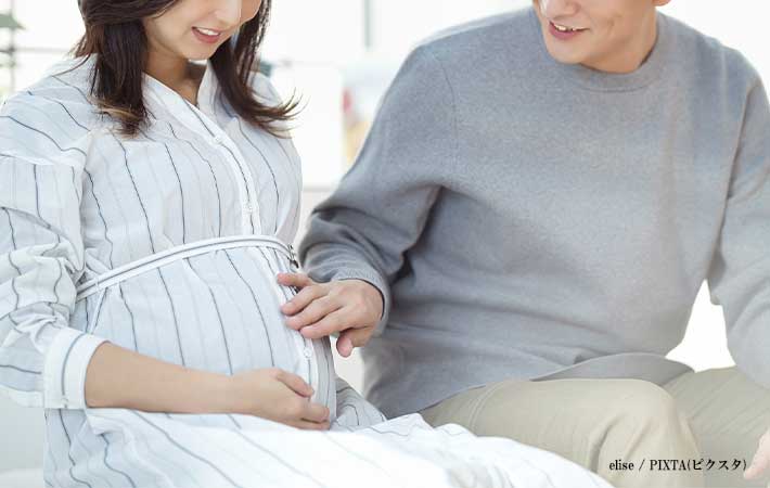 妻のお腹をさする夫