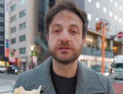 日本のコンビニのたまごサンドを食べるアメリカ人男性の写真