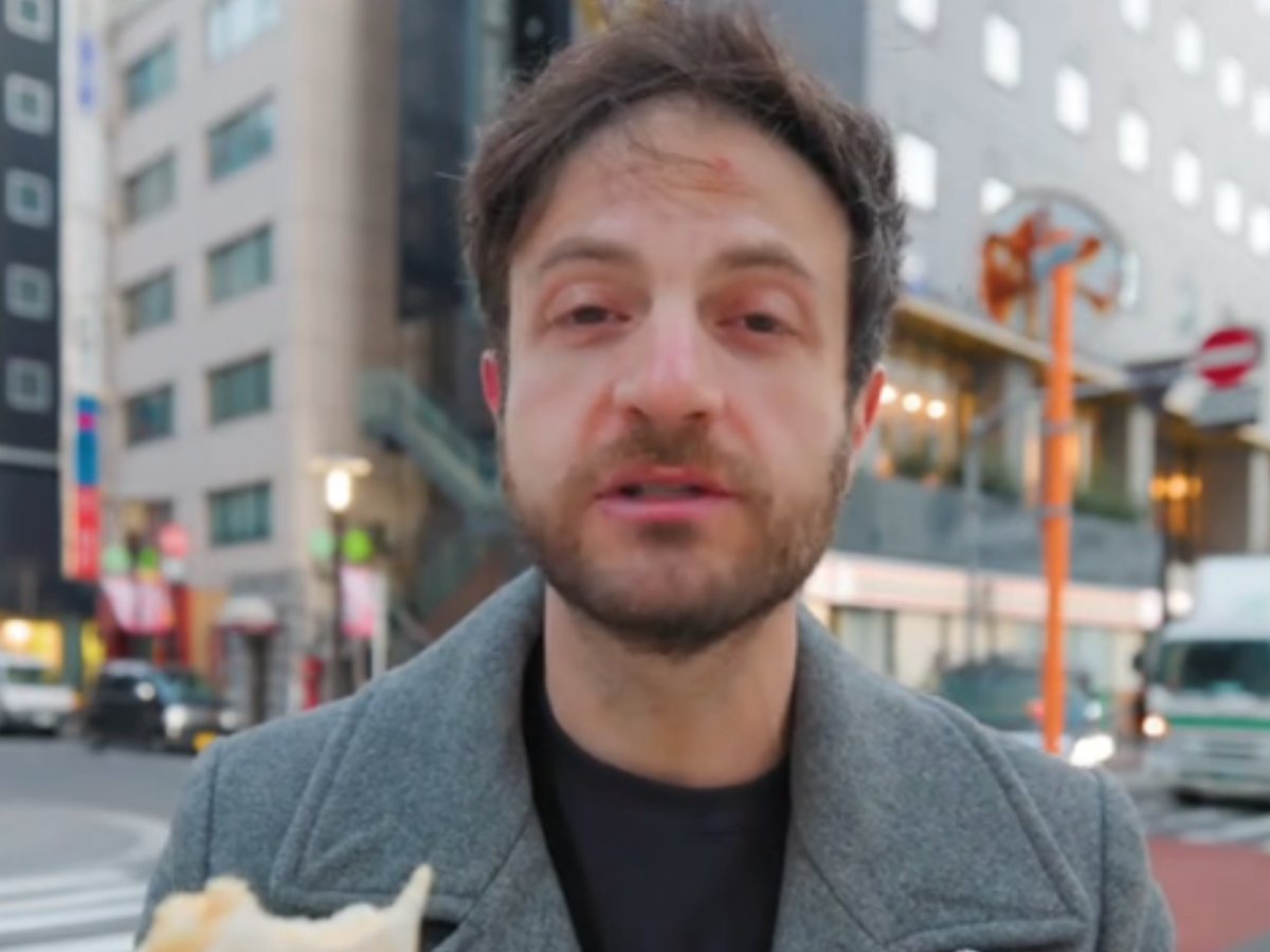 日本のコンビニのたまごサンドを食べるアメリカ人男性の写真