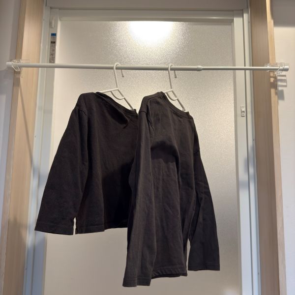 かもいフックとつっぱり棒で作った物干しスペースにハンガーに掛けた洋服を干した様子