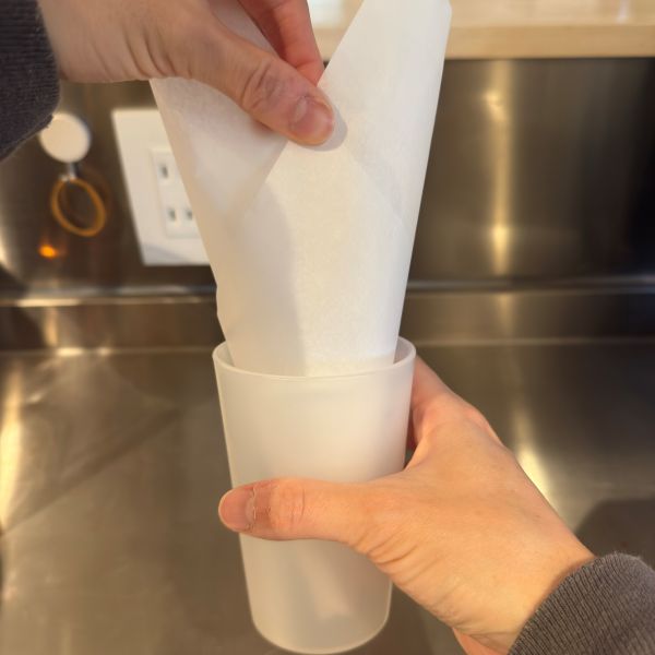 グラスに逆三角形にしたクッキングシートを入れる様子
