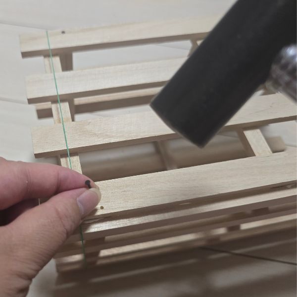 すのこにくぎを打ち込む様子