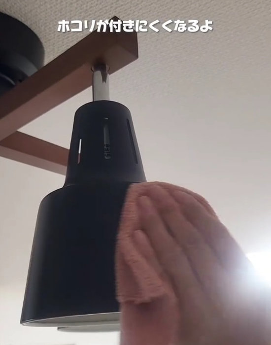 照明器具を雑巾で拭いている様子