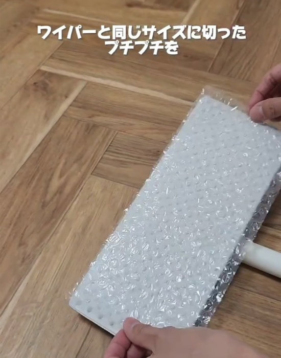 フローリングワイパーに気泡緩衝材を取り付けている様子