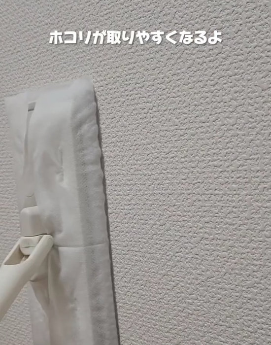 フローリングワイパーで壁を掃除している様子