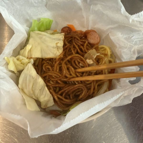 クッキングシートで包んで加熱した麺と具材を箸で混ぜ合わせる様子