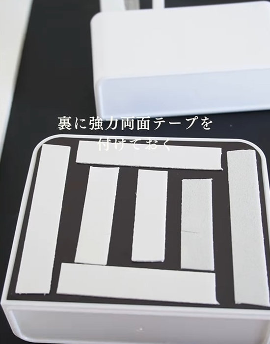 収納ケースに両面テープを貼っている様子