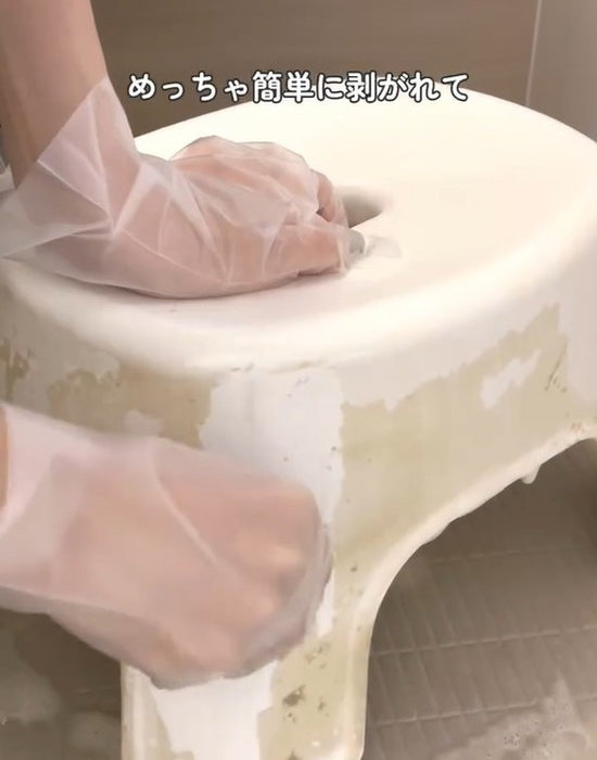 お風呂の椅子の汚れをカードで落としている様子