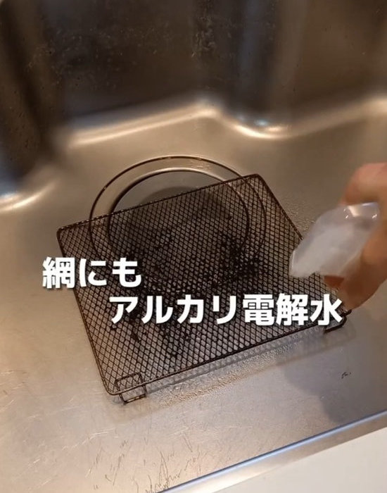 網にアルカリ電解水を吹きかけている様子