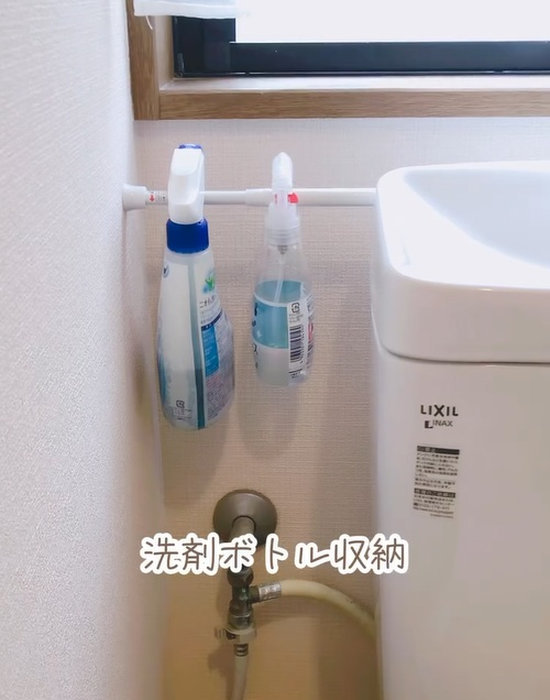 突っ張り棒で作った収納にスプレーを吊り下げている様子