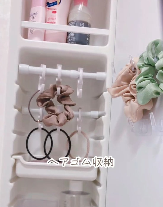 突っ張り棒で作った洗面収納にヘアゴムをかけている様子