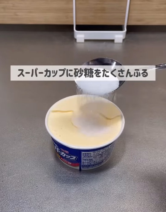 スーパーカップのアイスに砂糖を振りかける様子