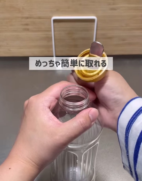 スプーンの柄で調味料用ペットボトルのキャップを取る様子