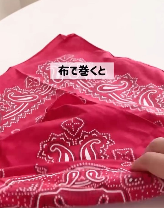 温めた保冷剤を布で巻いている様子