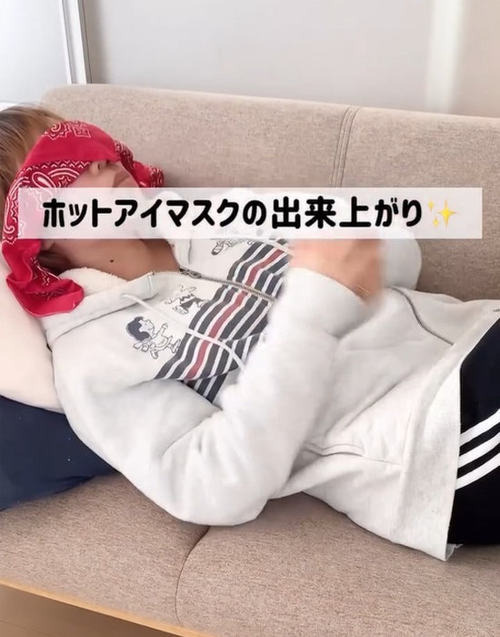 温めた保冷剤を目に当てている人