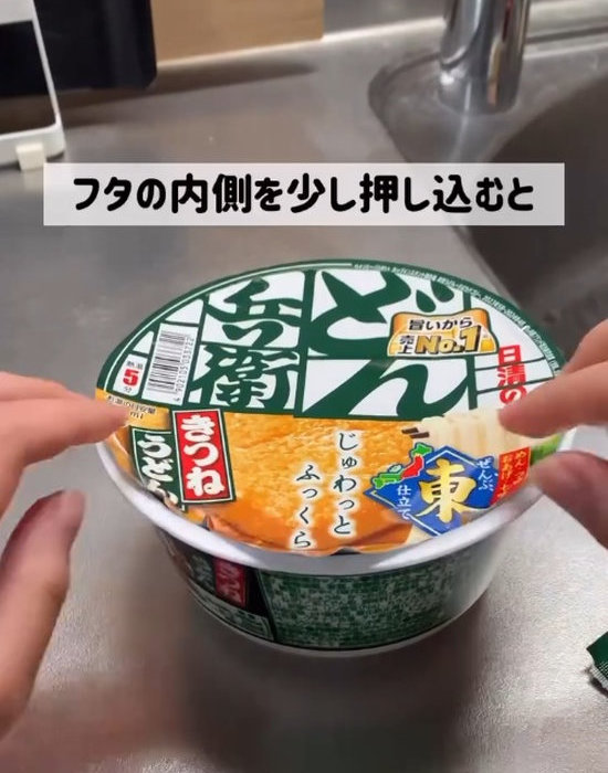 カップ麺の蓋を内側に押し込んでいる様子