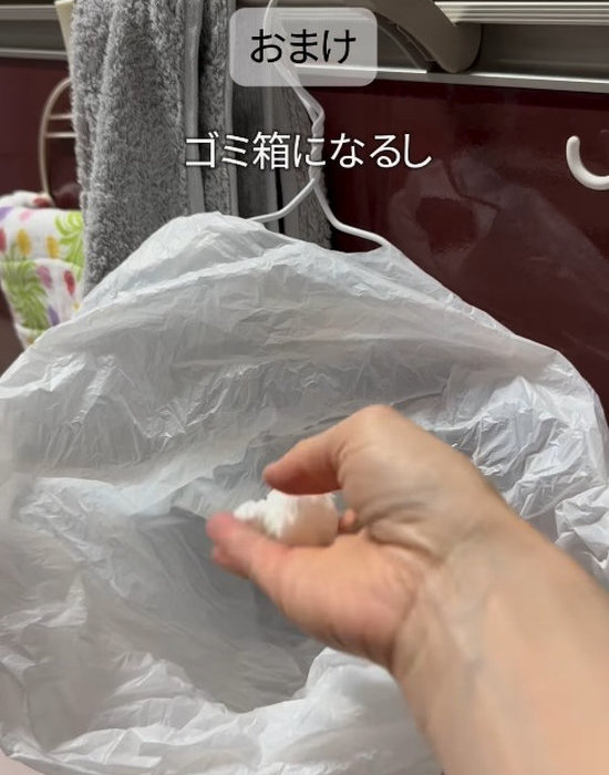 曲げたハンガーにゴミ袋をかける様子