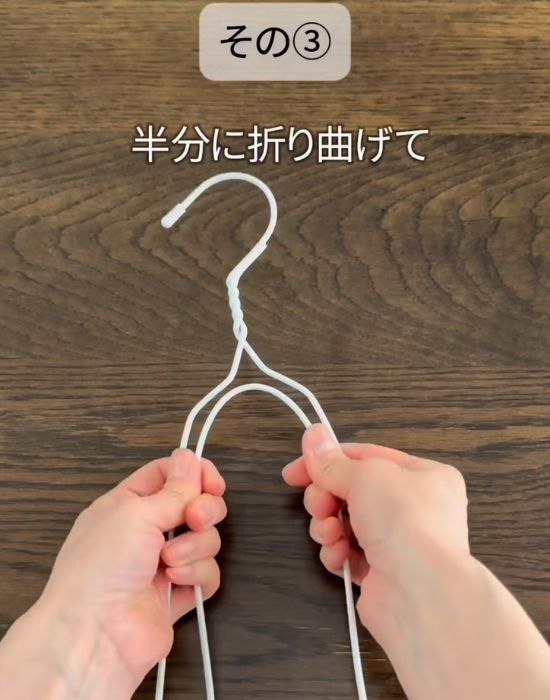 針金ハンガーを半分に折り曲げている様子