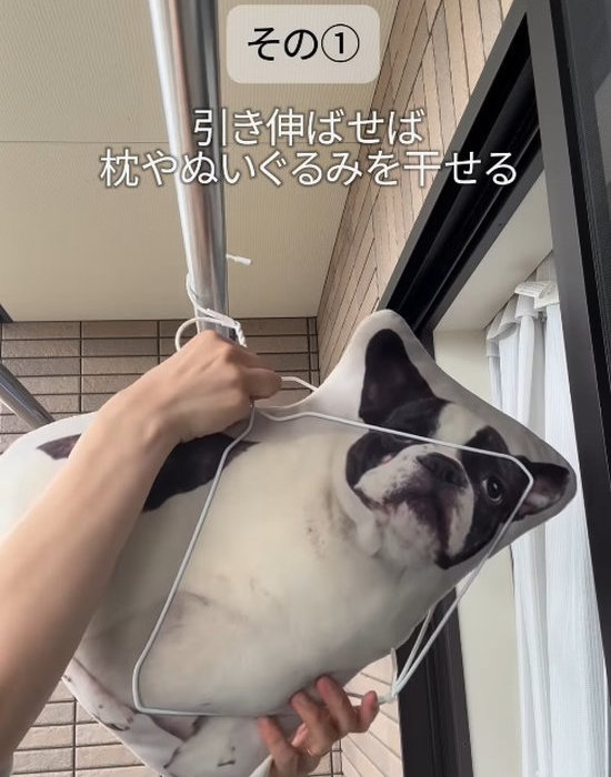 つなげたハンガーにクッションを吊るして干す様子