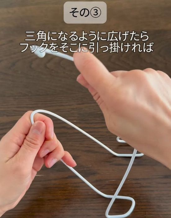 曲げたハンガーを手にしている様子