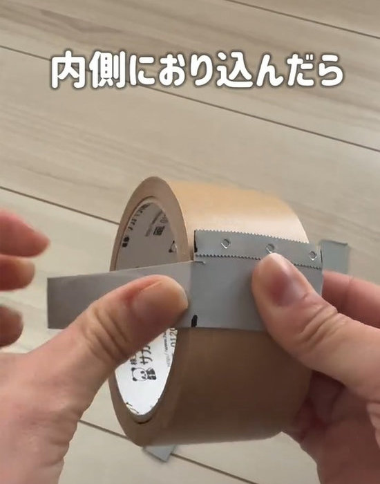 ラップ用カッターをクラフトテープに沿わせて折り込む様子