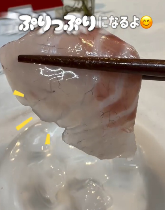 氷水に漬けた刺身を箸で取る様子