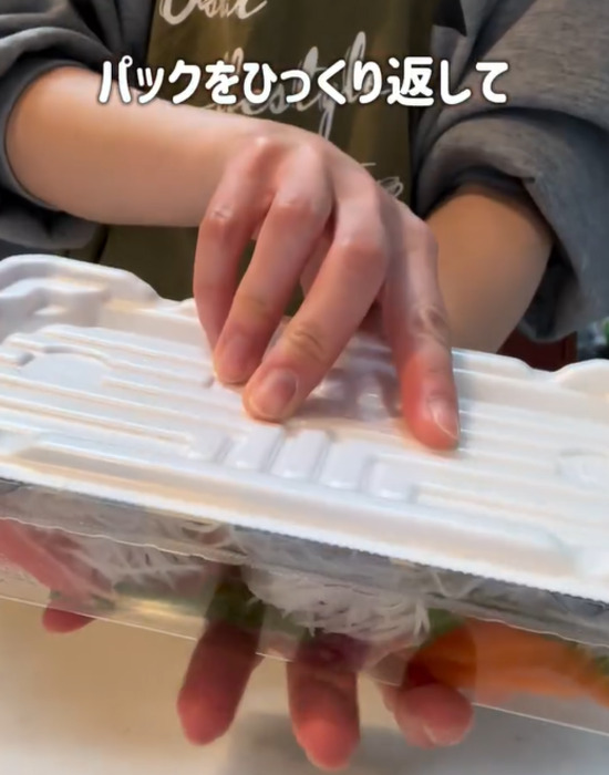 刺身のパックをひっくり返す様子