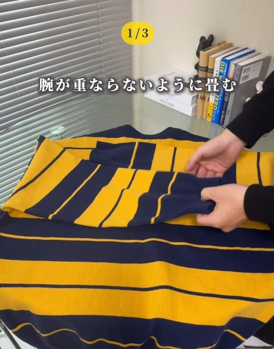 中心に向かって袖を畳む