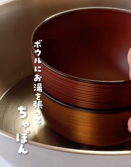 重なったお椀をお湯に浸けている画像