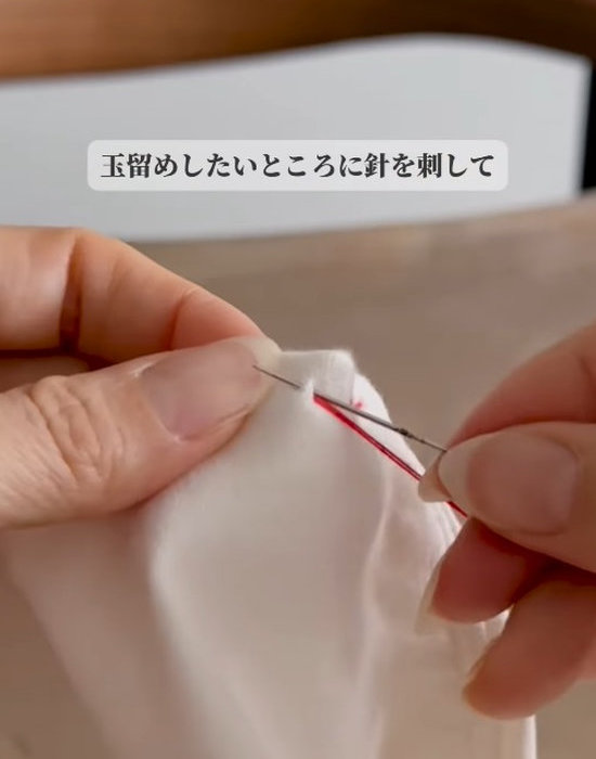 ズボンに針を刺している様子