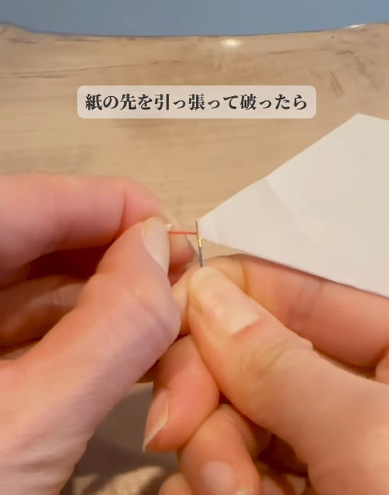 針穴から出ている糸を引っ張っている様子