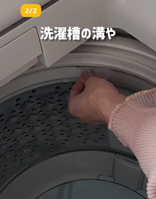 三角形に切ったクリアファイルの角で洗濯機の溝を掃除している様子