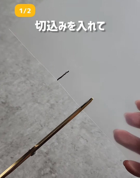 クリアファイルに切り込みを入れている様子