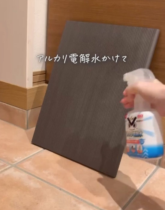 靴箱の仕切り板にアルカリ電解水を吹きかける様子