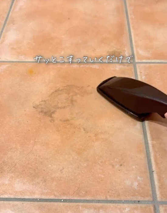 ホコリ取りでタイルの汚れをこする様子