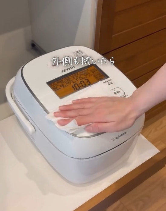炊飯器の外側を掃除している画像
