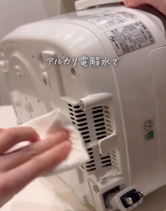炊飯器の吸気口を布で拭いている画像
