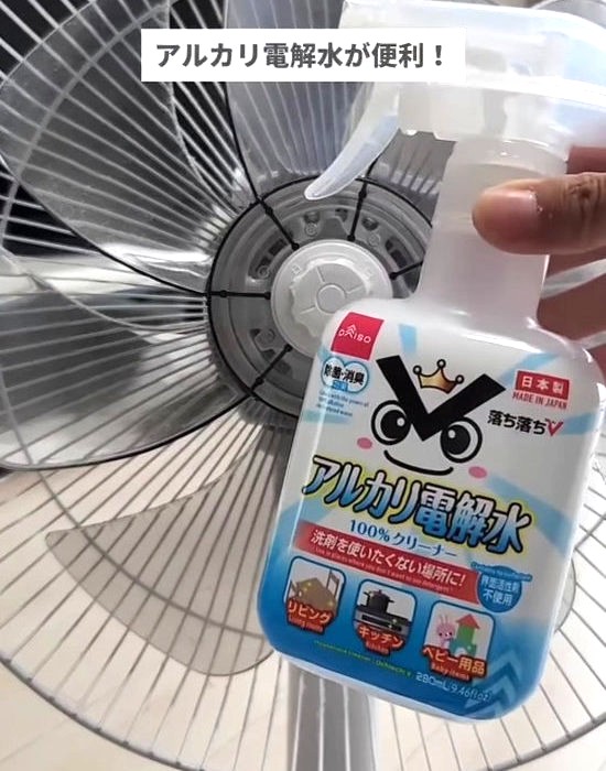 扇風機とアルカリ電解水を手にしている様子