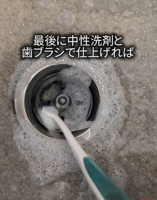 排水口を歯ブラシで洗う様子