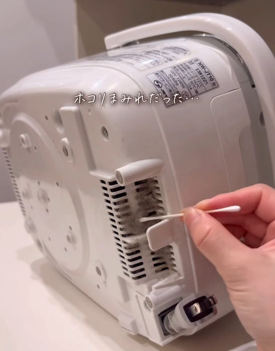 炊飯器の裏のホコリを綿棒で取る様子