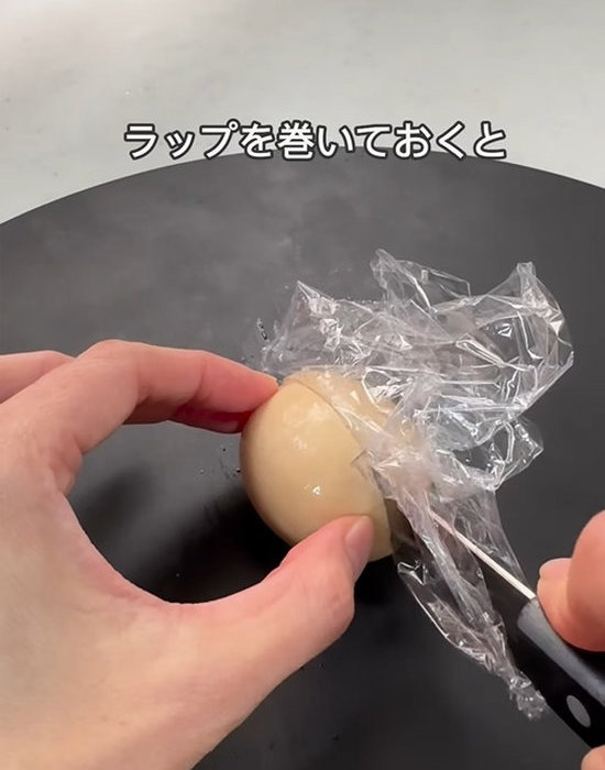 ラップを巻いた包丁で味玉をカットする様子