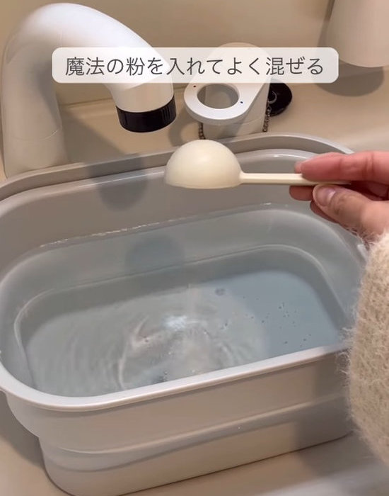 お湯をためたバケツに過炭酸ソーダを入れている様子